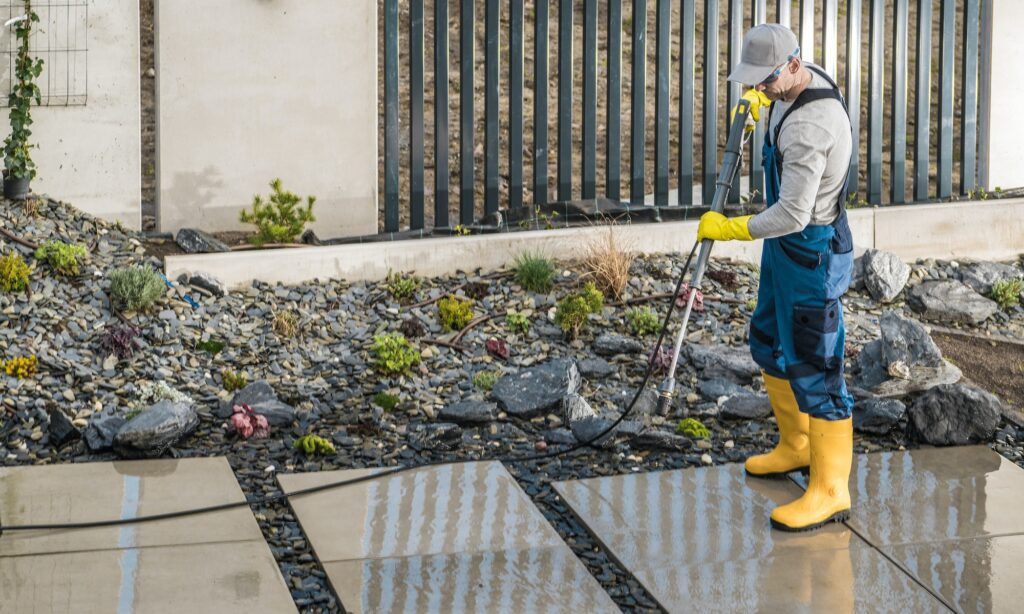 Man Pressure Washing Concrete Tiles